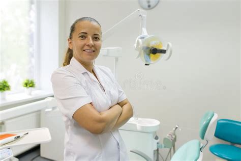 Portrait Of Female Dentist With Crossed Arms Doctor Smiling On Dental