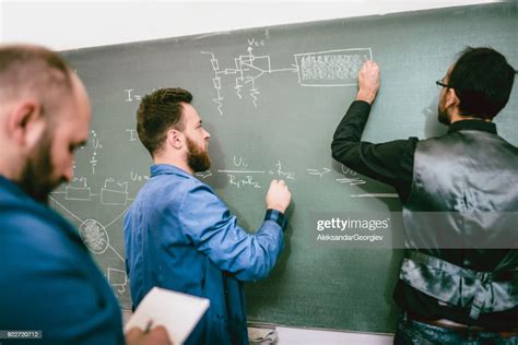 Engineer Student Solve Electrical Problems On Blackboard In Front Of
