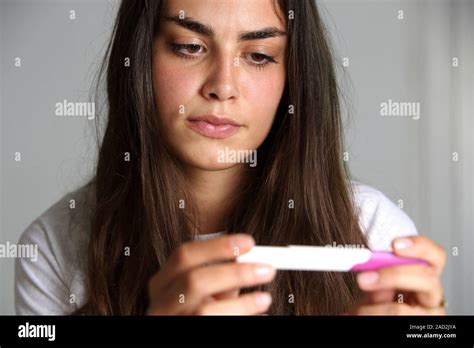 teenage girl with a pregnancy test 18 year old girl looking at the results of a pregnancy test