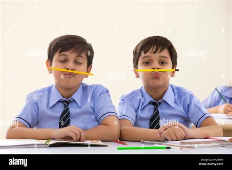 Two School Boys Playing With Pencils In Class Stock Photo Alamy