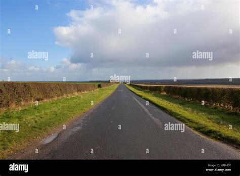 A Quiet Country Road Through The Yorkshire Wolds Landscape Under A Blue