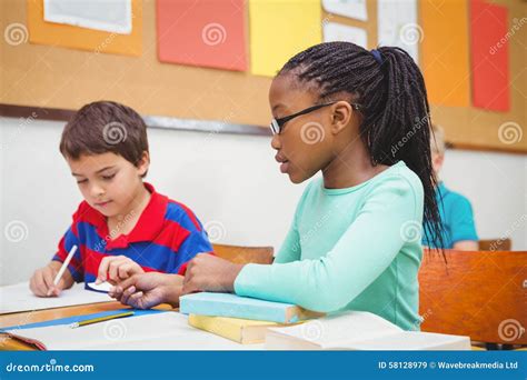 Estudiante Que Ayuda Al Estudiante Compañero En Clase Imagen De Archivo