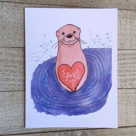 a card with an otter holding a heart in the water
