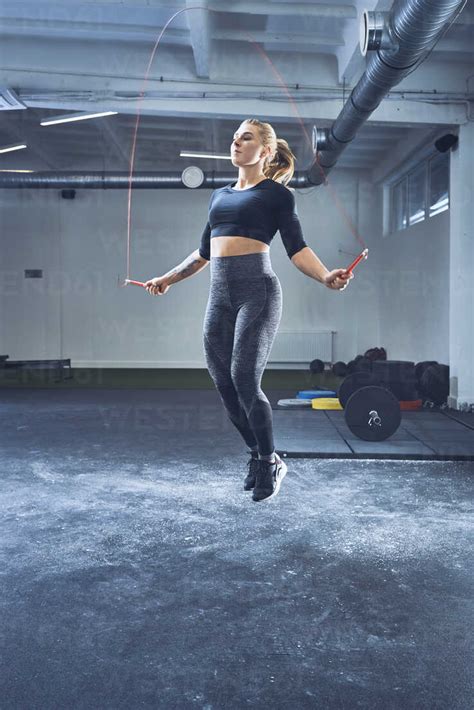 Athletic Woman Skipping With Jumping Rope In Gym Stock Photo