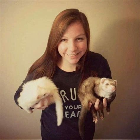 A Woman Holding Two Ferrets In Her Hands