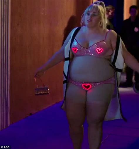 Rebel Wilson Lets It All Hang Out As She Strips Down To Her Flashing Neon Underwear In Clip For