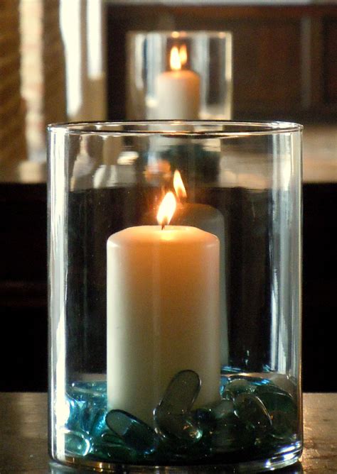 Pretty Way To Add Light To A Room With Large Candles In Glass Vases And Blue Marbles In The