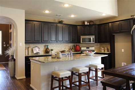 Combining two colours for the cabinets can instantaneously revitalize the entire kitchen, no matter the colours you choose, whether they are dynamic or dark colors. Dark brown kitchen cabinets by Burrows Cabinets in Espresso