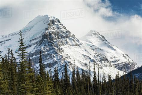 Close Up Of Two Snow Covered Mountain Peaks With Cloud Cover And Some