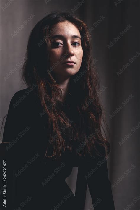 beautiful girl 17 18 years old with long hair and freckles a serious look in the camera