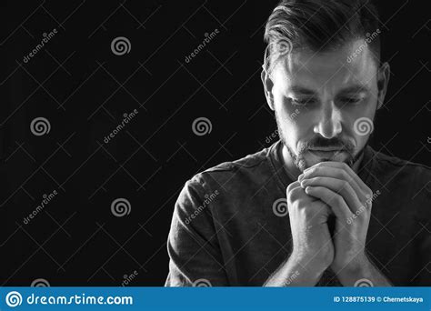 Man With Hands Clasped Together For Prayer On Dark Background Black