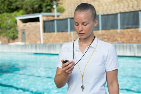 Swim Coach Looking At Stopwatch Near Poolside Stock Image Image Of