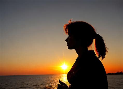 Premium Ai Image Woman Silhouette Watching Sun In A Sunset