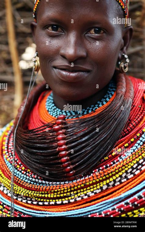 A Young Samburu Woman Smiling In Traditional Attire In A Remote