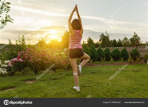 Young Girl Practicing Yoga Meditating Summer Sunset Background Green