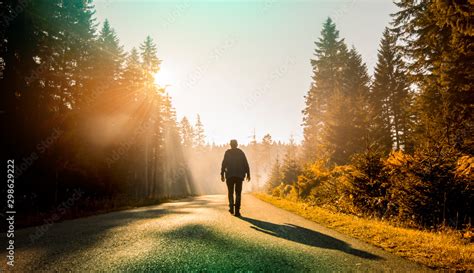Man Walking On Country Road At Sunset Stock Photo Adobe Stock