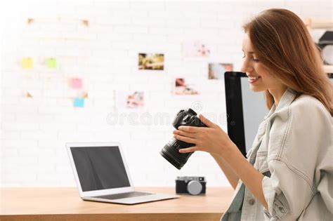 Professional Photographer With Camera Working At Table Stock Photo