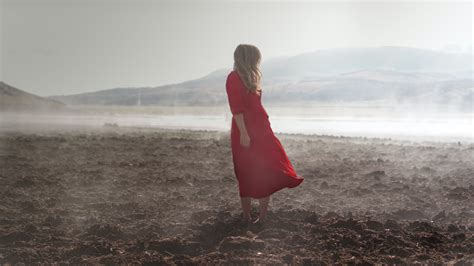 Woman In Red Dress Standing On Brown Soil Near Body Of Water · Free