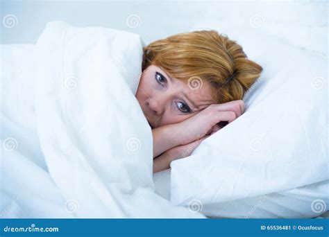 Young Woman Lying In Bed Sick Unable To Sleep Suffering Depression And