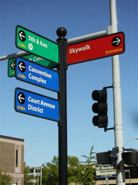 Street Signs Pointing In Different Directions On A Pole With Traffic