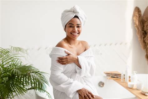 Pretty Black Female Posing Sitting On Bathtub In Bathroom Stock Image