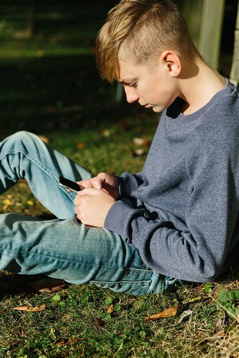 Teenage Boy Using A Mobile Phone Outdoors by Helen Rushbrook - Technology, Teenager
