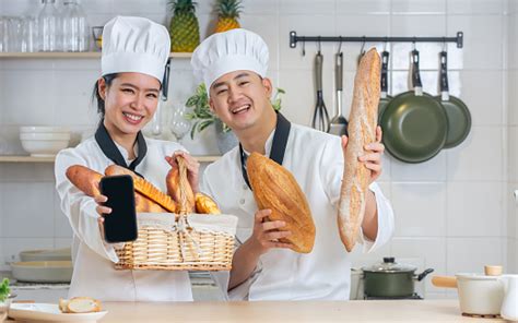 Two Asian Professional Chef Wearing White Uniform Hat Holding Basket Of Breads Baguettes Mobile