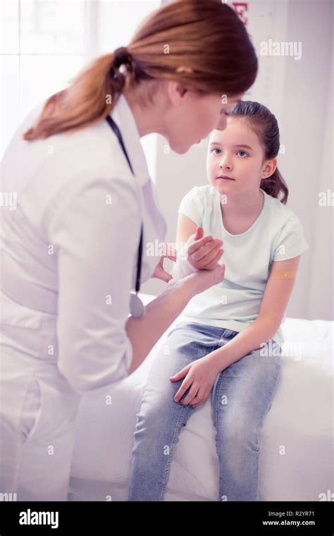 Dark Haired Girl Sitting On Bed In The Hospital After Breaking Her Arm