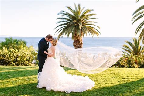 Bride In Demetrios Groom In Ermenegildo Zegna Kiss On Grass Ocean View