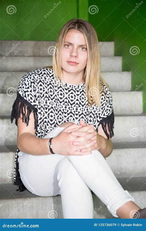 Het Mooie Tiener Blonde Meisje Zit Op Straattreden Stock Afbeelding