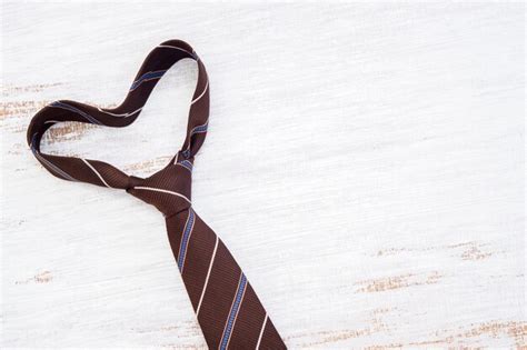 Premium Photo Necktie In Heart Shape On Grunge White Wooden Table