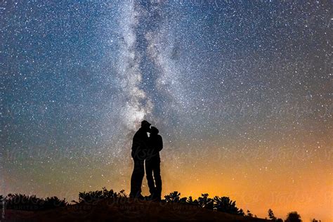 silhouette of couple kissing under milky way galaxy night sky by stocksy contributor jp danko