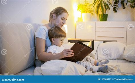 Portrait Of Beautiful Young Mother Reading Story To Her Baby Son Stock