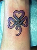 Purple Celtic shamrock tattoo on wrist