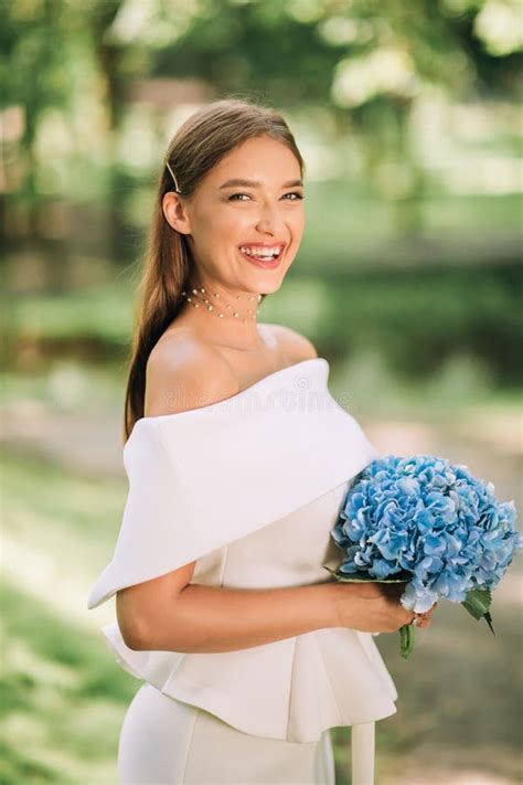Happy Bride In Beautiful White Dress Holding Bouquet Standing Outside