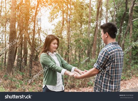 Romantic Couple Clasped Hands Backlit By Stock Photo 552078028