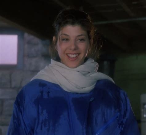 A Woman Wearing A Blue Coat And White Scarf Smiles At The Camera While