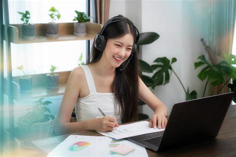 Asian Woman Talking With Other Meeting Members By Computer Deskt