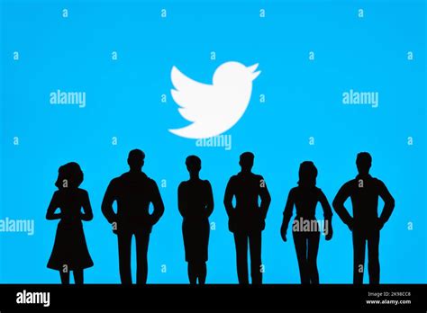 People Figurine Silhouettes Are Seen In Front Of Blurred Twitter Logo