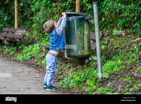 Little Child Throwing Trash In The Bin Stock Photo Alamy