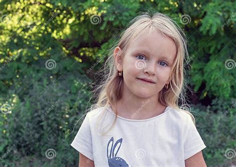 Adorable Child Six Year Old Blonde Against The Background Of Nature