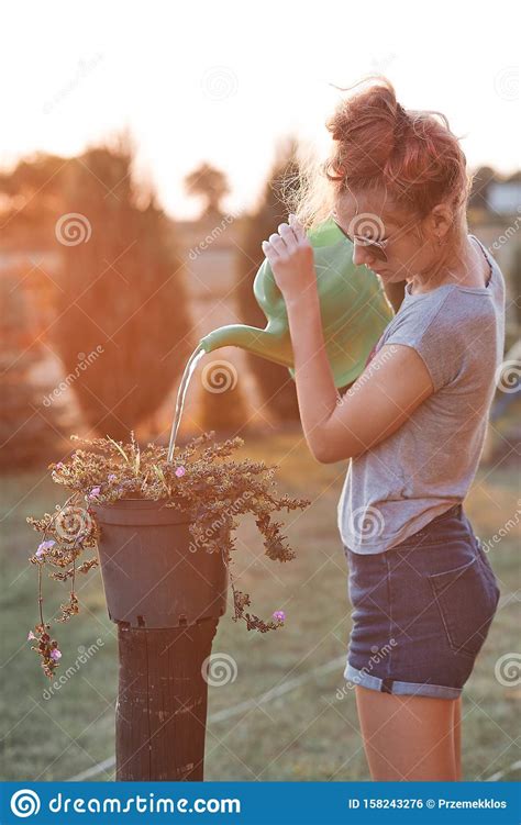 Adolescente Ayudando A Regar Las Flores Foto De Archivo Imagen De Cabrito Gente