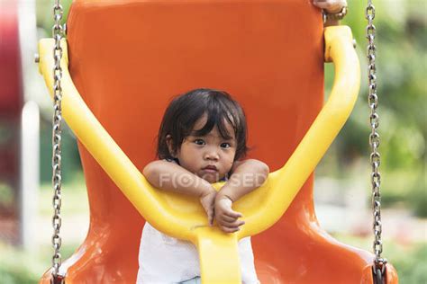 Cute Adorable Asian Little Girl On Swing At Playground — Copy Space