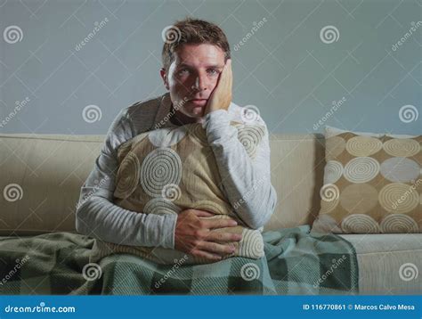 Young Sad And Desperate Man At Home Sitting At Sofa Couch Suffering