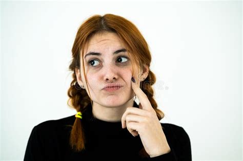 Portrait Of Serious Young Woman Holding Her Hands To Face Thinking