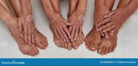 Close Up Of Well Groomed Hands With Manicure On Female Feet Of Mature Women Isolated Over White