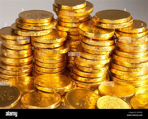 A Stack Of Gold Chocolate Coins Wrapped In A Golden Foil Stock Photo