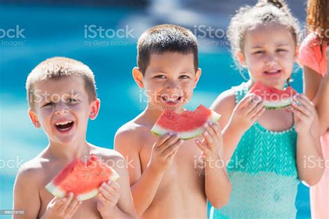 Children Eating Watermelon By Swimming Pool Stock Photo Download
