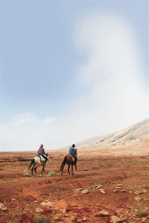 Young Couple Riding Horses In The Desert By Stocksy Contributor