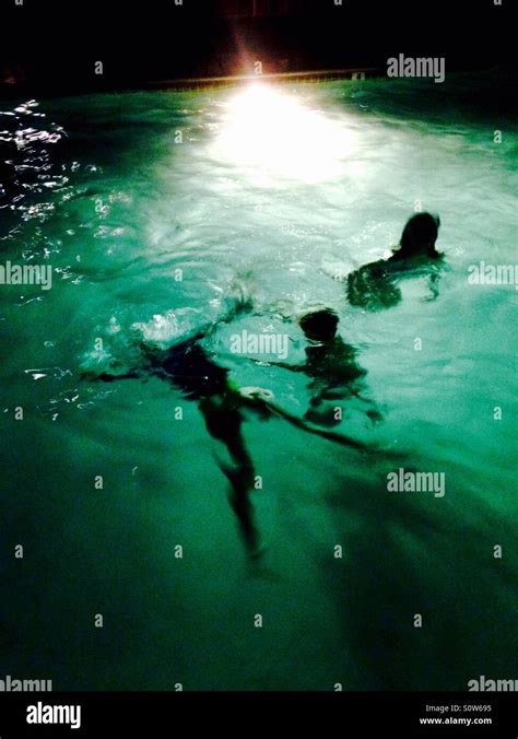 Children Swimming In Lighted Pool At Night Stock Photo Alamy